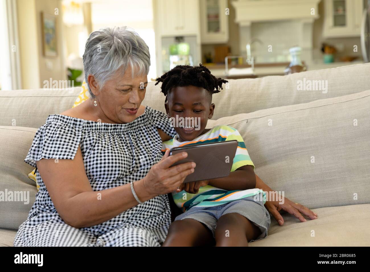 Ältere gemischte Rasse Frau mit ihrem Enkel zu Hause Stockfoto