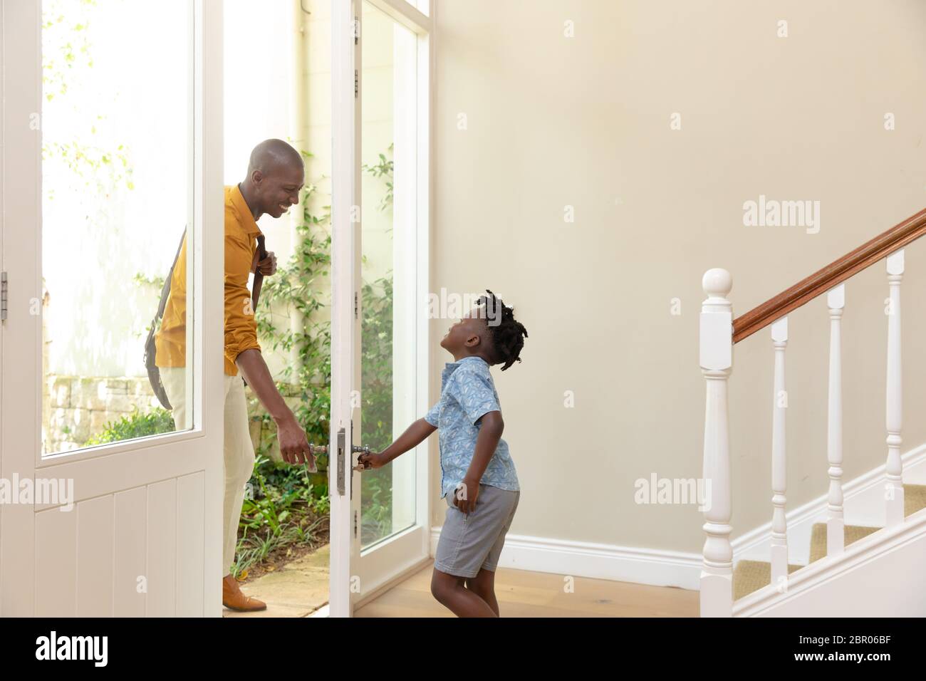 Afroamerikanischer Mann, der mit seinem jungen Sohn nach Hause kommt Stockfoto