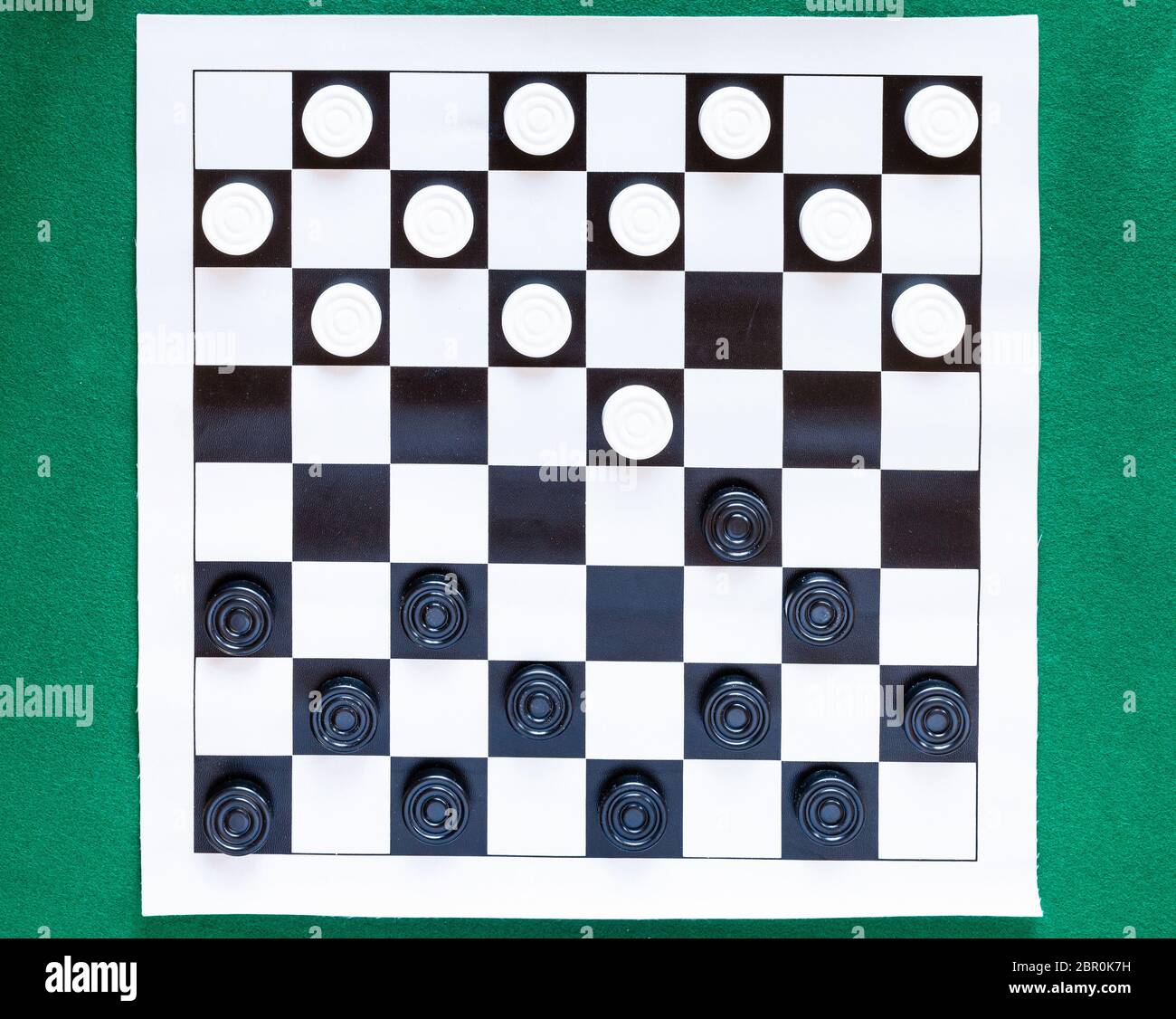 Blick von oben auf die Steine auf schwarz-weiß karierten Blatt Board auf grünem Filz Tisch Stockfoto