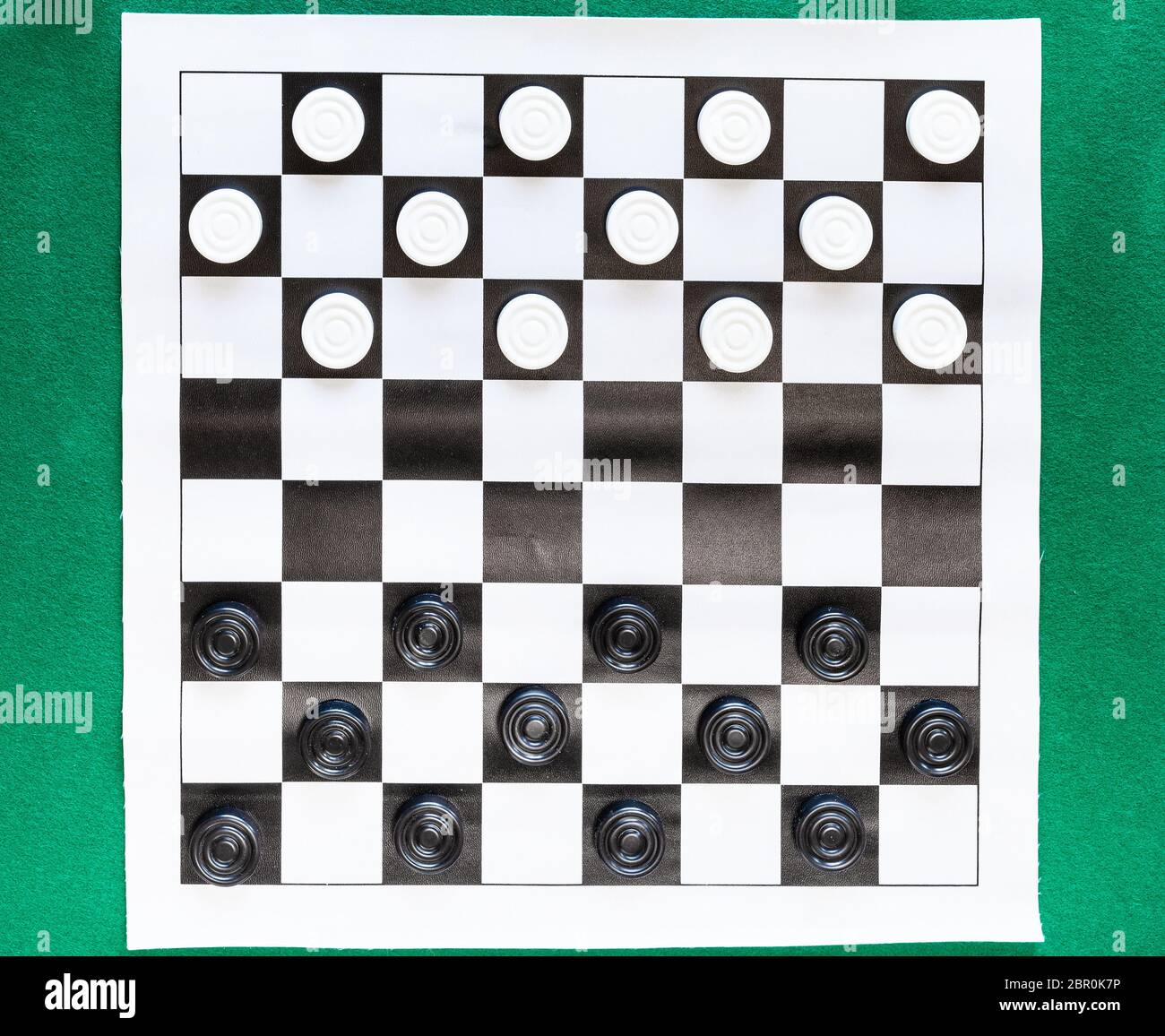 Blick von oben auf die Entwürfe auf schwarz-weiß karierten Blatt Board auf grünem Filz Tisch Stockfoto