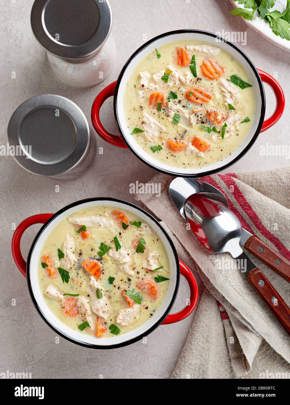 Blick von oben auf zwei Schalen mit cremigem Huhn und Gemüsesuppe Stockfoto