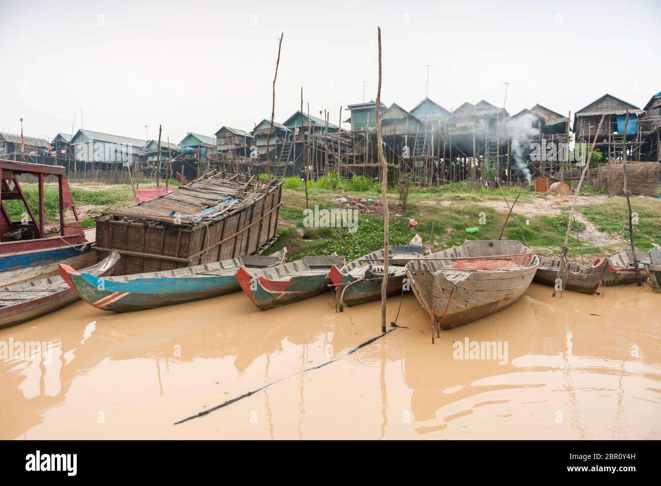 Boote auf dem Fluss mit Häusern auf Stelzen im Hintergrund bei Kampong Phluk, Provinz Siem Reap, Nord-Zentral Kambodscha, Südostasien Stockfoto