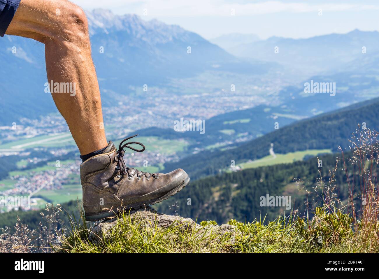 Nahaufnahme eines Lederwanderschuhs und der Wadenmuskulatur eines Mannes an einem sonnigen Tag im Zillertal in den österreichischen alpen Stockfoto