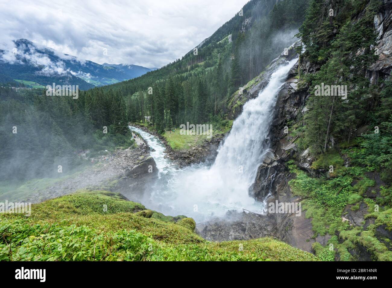 Idyllische Sicht auf die Krimmler Wasserfälle und den umliegenden Wald an einem wolkigen und nebligen Tag in Österreich bei Salzburg. Majestätischer Strom fließt am h Stockfoto