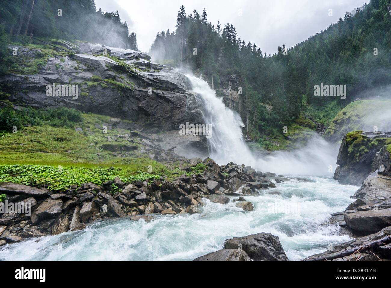 Blick auf die Krimmler Wasserfälle von unten an einem nassen und bewölkten Tag in Österreich. Majestätischer Bach, der am höchsten Wasserfall europas fließt Stockfoto