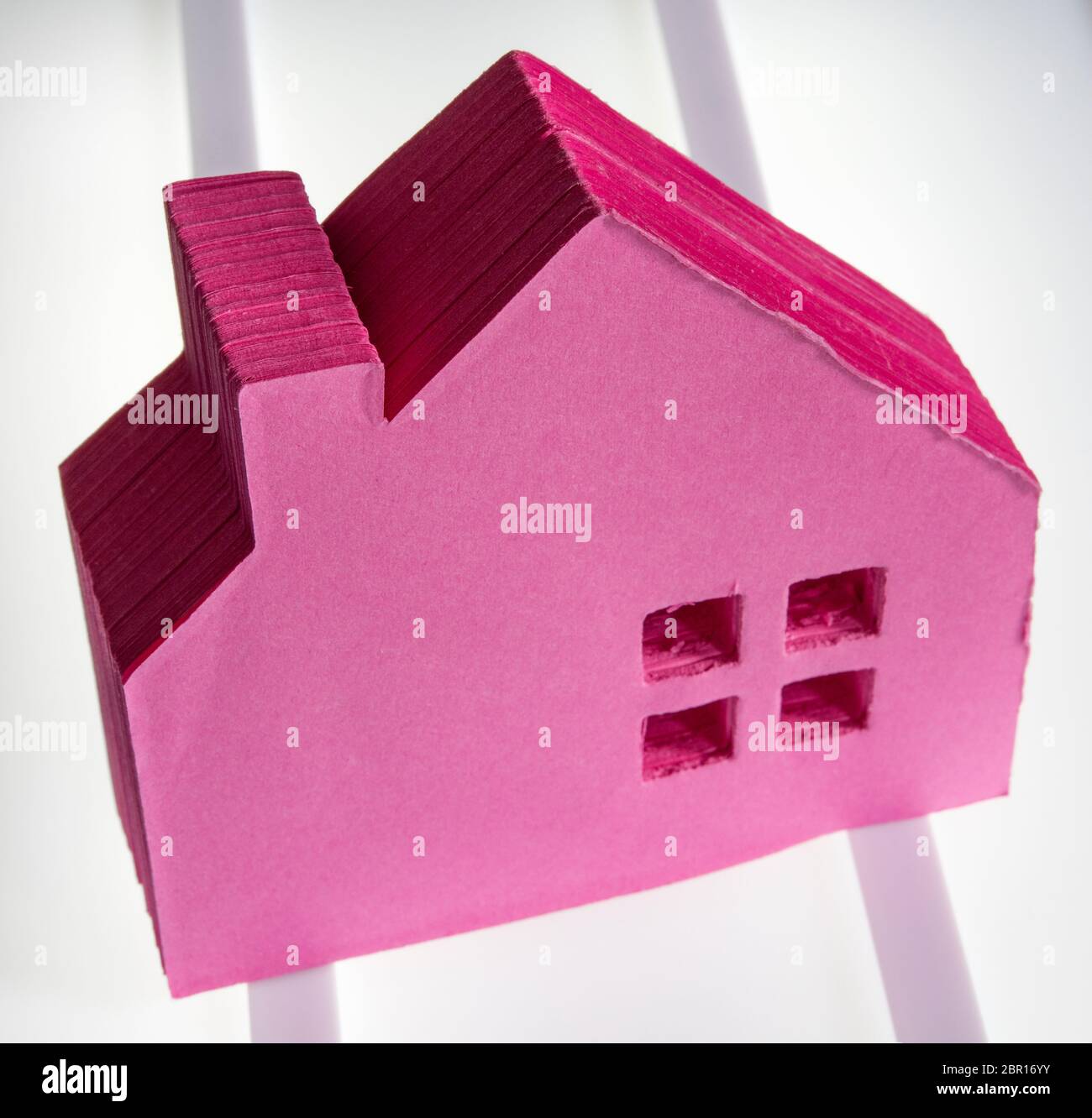 Ein rosa Papierblock in Form eines Hauses Stockfoto