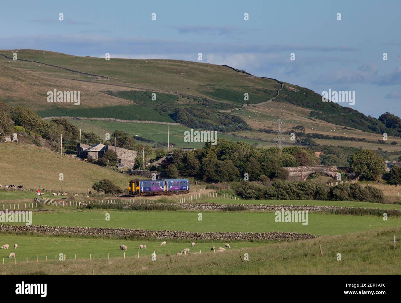 2 Nordbahn der Klasse 153 Einwagen-Sprinterzüge, die auf der malerischen Küstenbahn Cumbrian bei Silecroft durch die Landschaft fahren Stockfoto