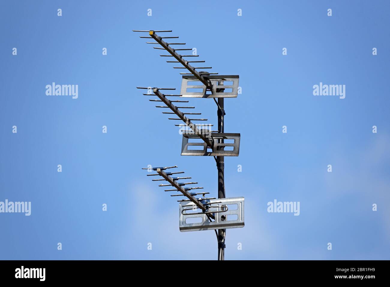 Drei TV Antennen auf einer Metallstange mit blauem Himmel Hintergrund Stockfoto