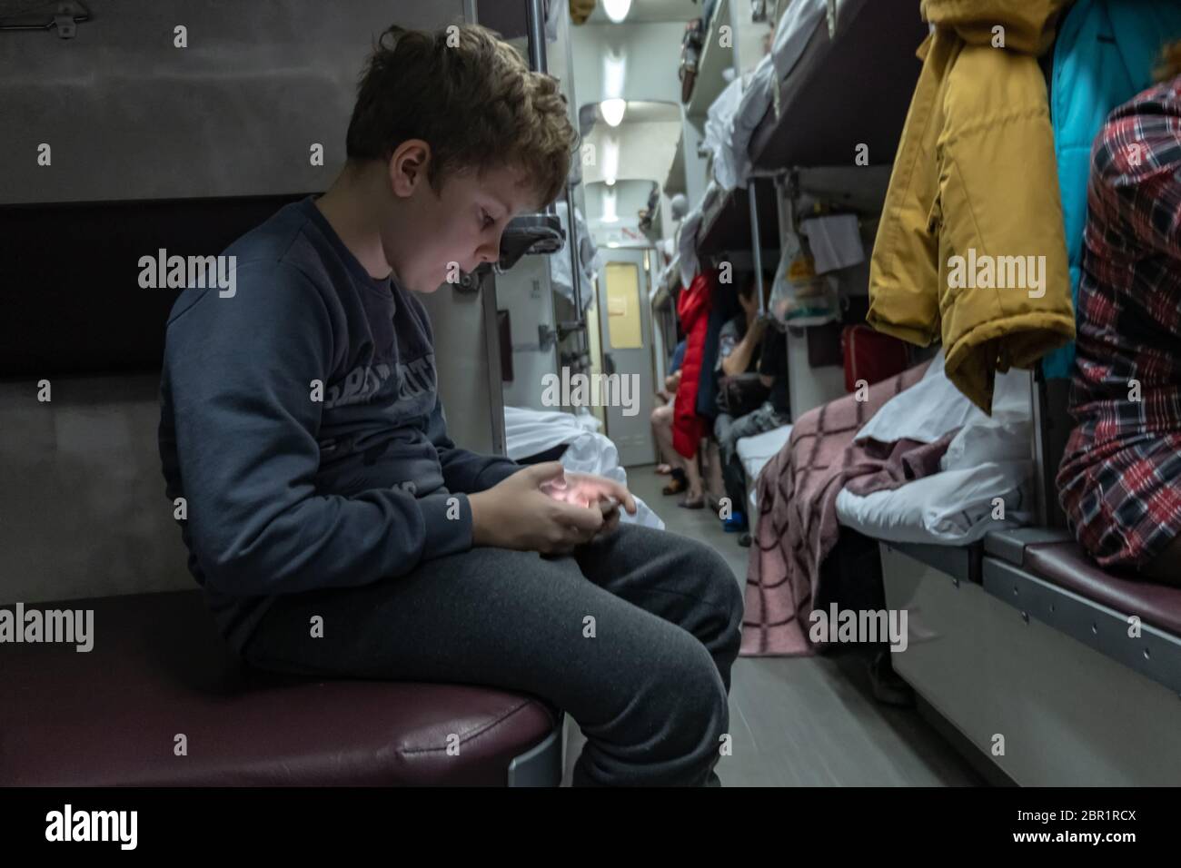 Nowosibirsk, Russland: Der russische Junge spielt mit seinem Handy bei Trans Siberian Express in der Umgebung von Nowosibirsk, Russland. Trainiere das Leben Stockfoto