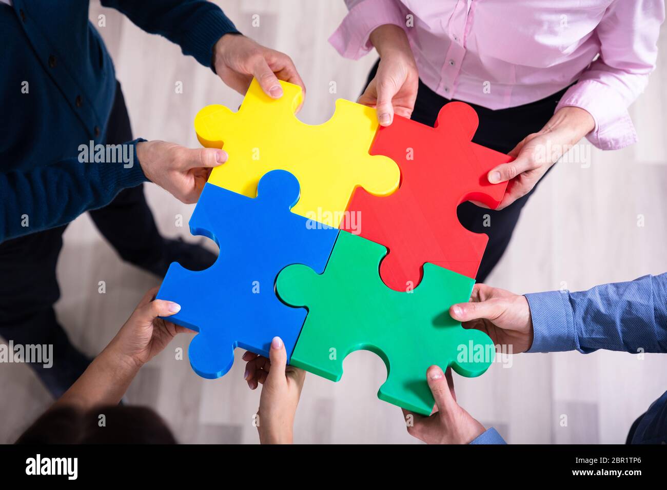 Einen erhöhten Blick auf Hände, die bunten Puzzle Stockfoto