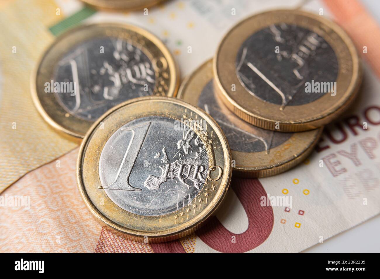 Im Hintergrund eine Euro-Münze und 5- und 10-Euro-Scheine Stockfoto
