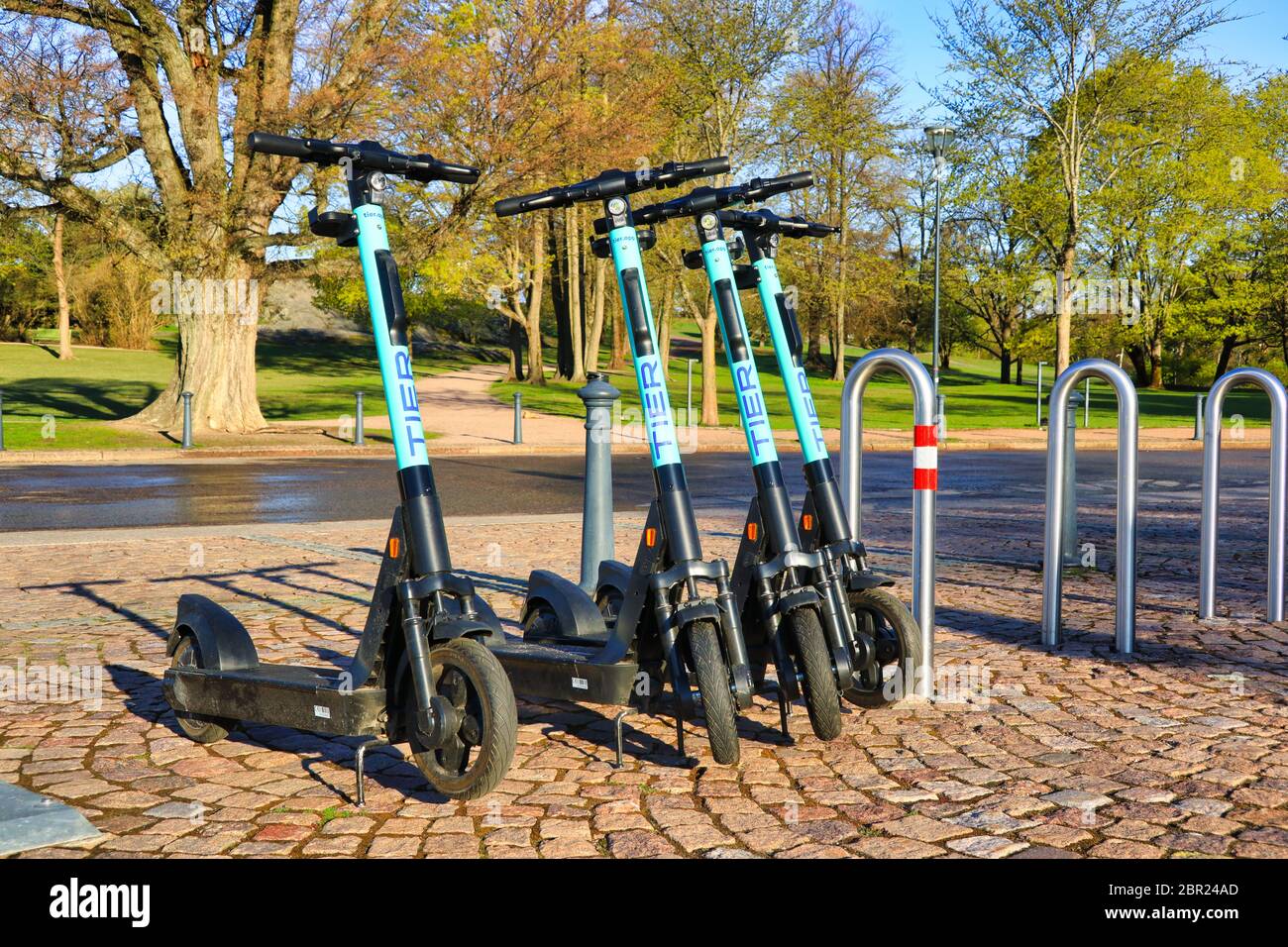 Tier-Elektro-Scooter oder E-Scooter in der Stadt am Park in frühen Morgenlicht geparkt. Helsinki, Finnland. 14.Mai 2020. Stockfoto