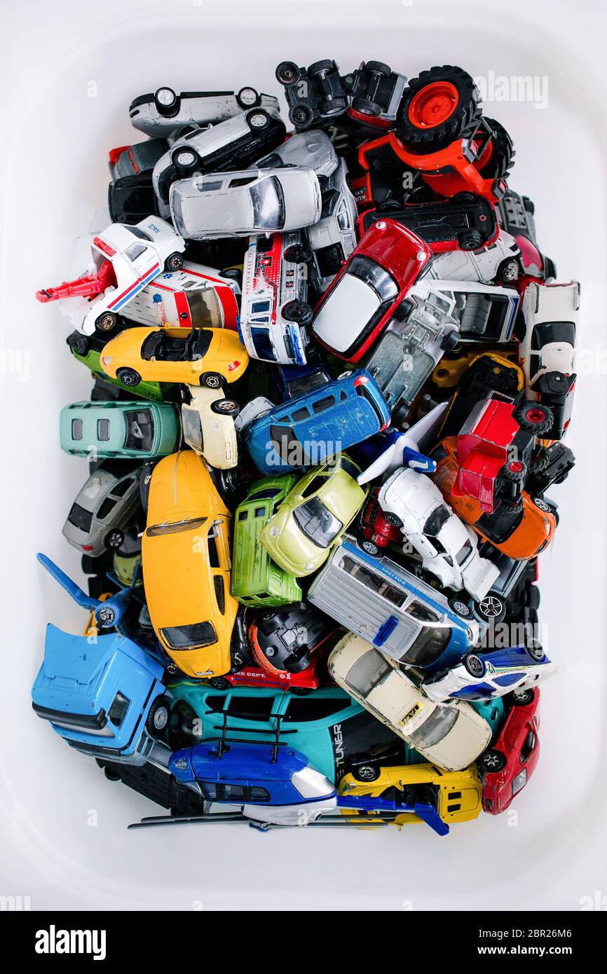 Haufen alter Mini-Spielzeugautos, die zusammen in den Aufbewahrungsbehälter  geworfen werden Stockfotografie - Alamy