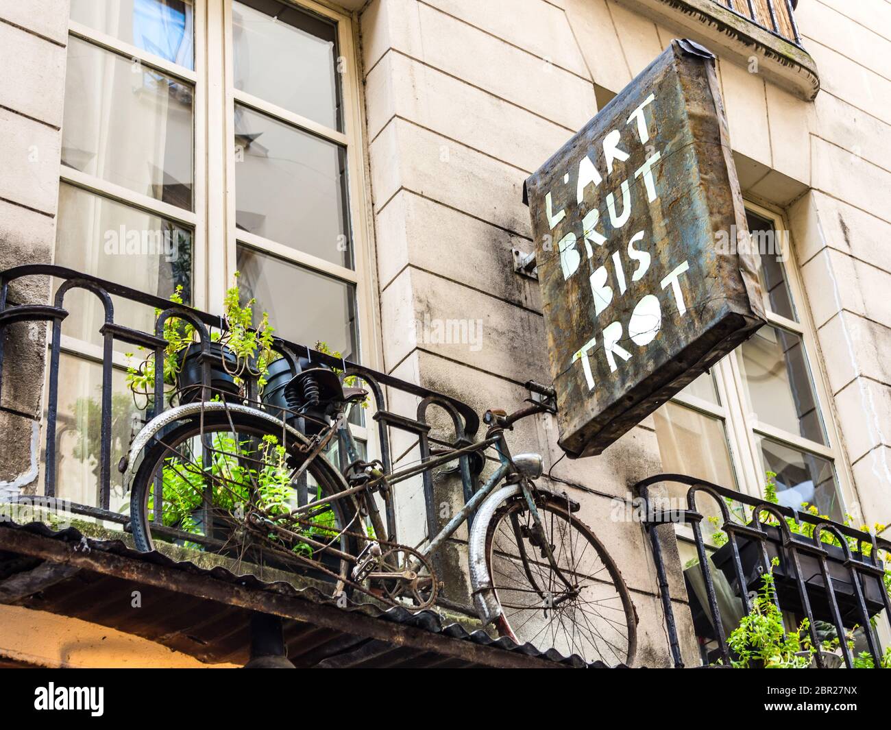 Fahrrad und Schild bei 'L'Art Brut Bistrot' Paris, Frankreich. Stockfoto