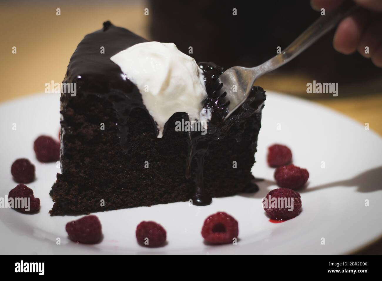 Schokoladenkuchen mit Ganache und Gabel Stockfoto