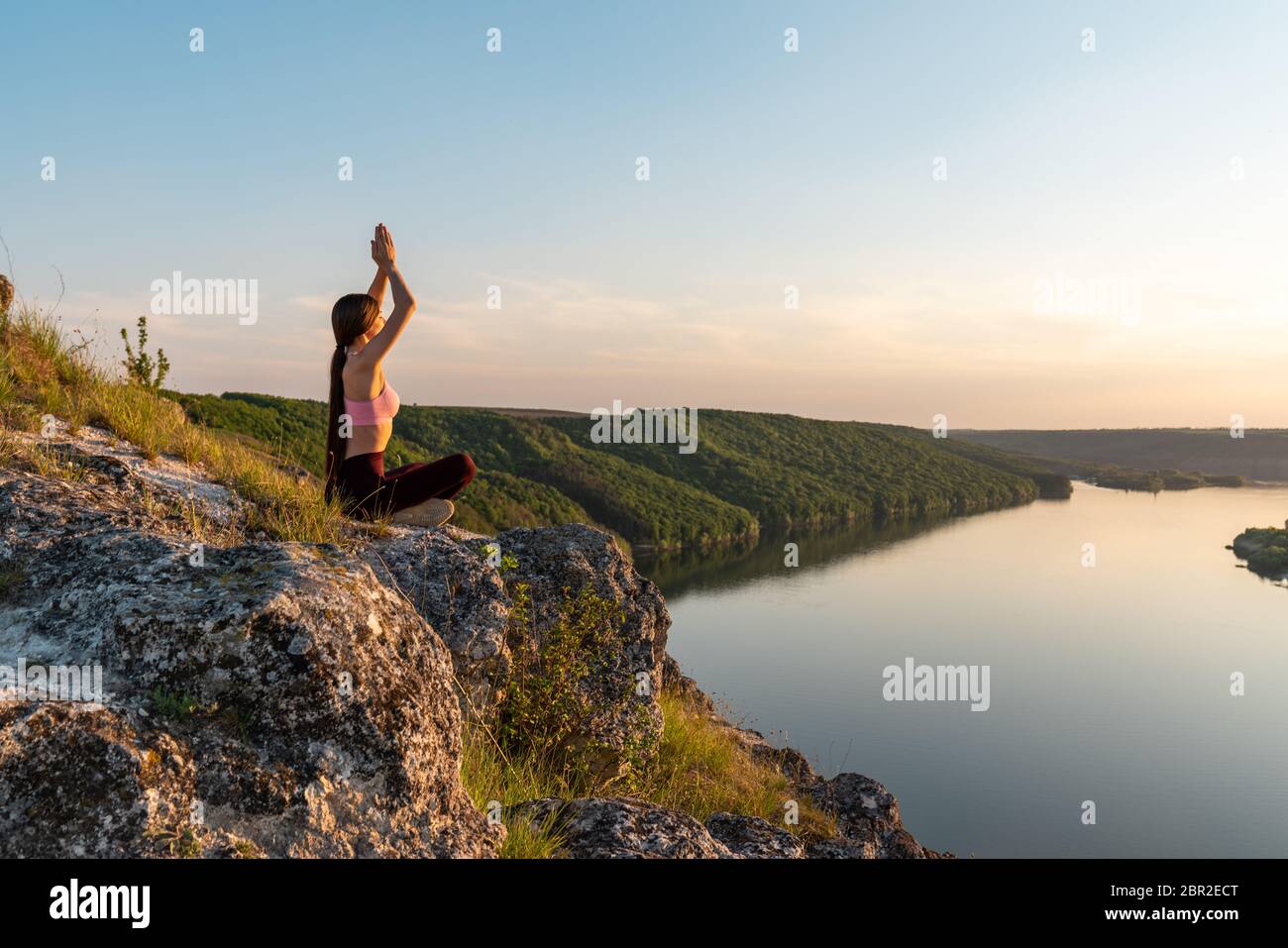 Junges Mädchen tun Yoga Fitness-Übung am Morgen Sonnenaufgang im Freien auf der Wiese schöne Berglandschaft Stockfoto