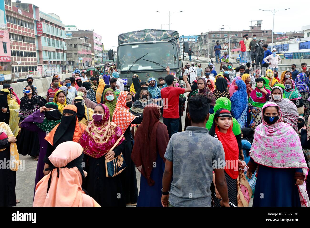 Dhaka, Bangladesch - 20. Mai 2020: Die Textilarbeiter aus Bangladesch blockieren eine Straße, während sie sich in einem Protest versammeln, der ihre unbezahlten Löhne während des ganzen Landes fordert Stockfoto