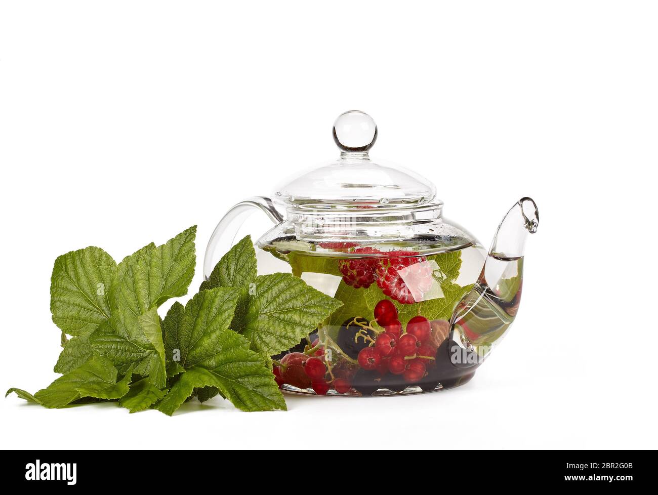 Teekanne mit Obst, Kaffee und grüne Blätter auf weißem Hintergrund Stockfoto
