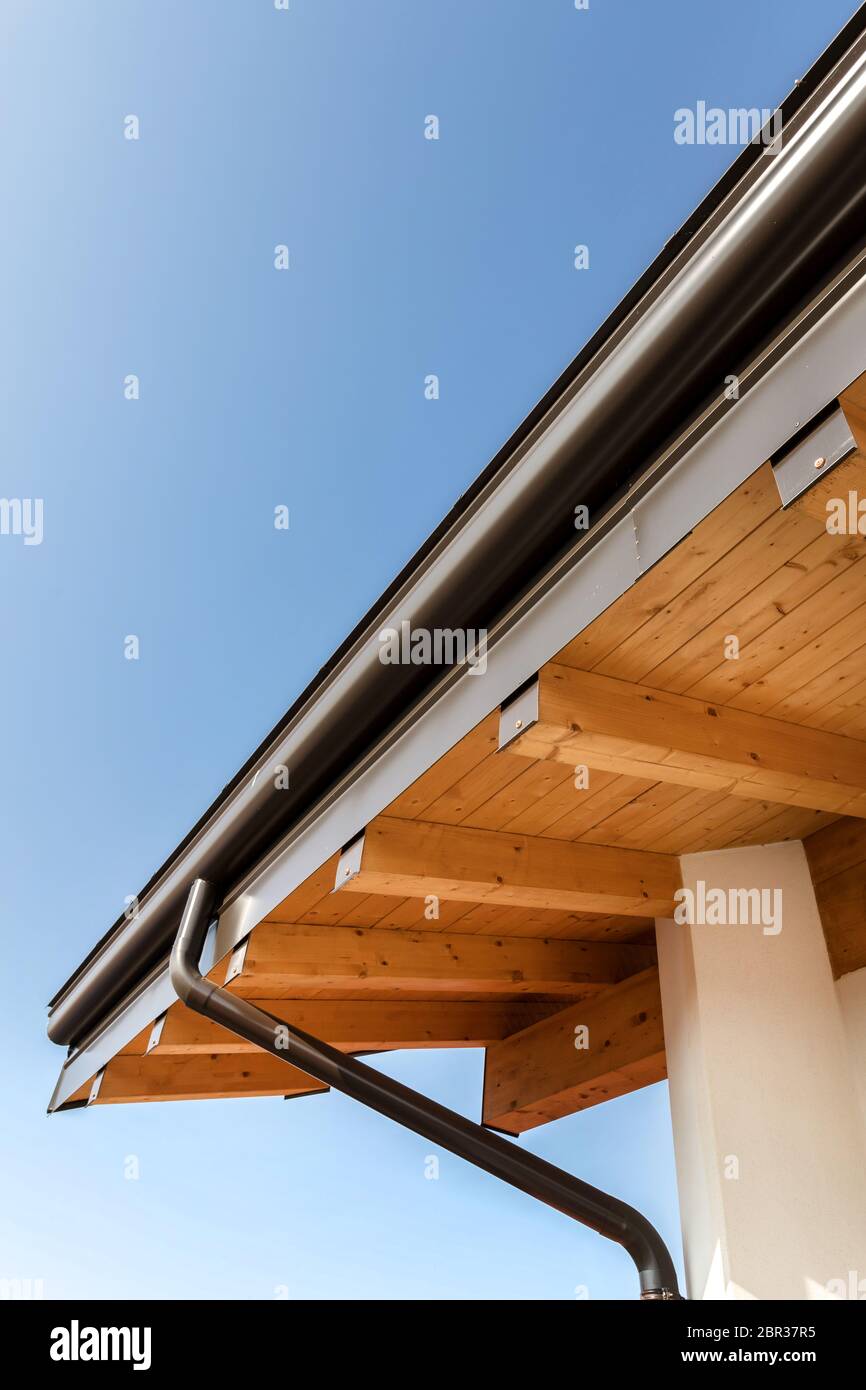 Neue Holz- warmen ökologischen Haus Dach mit Stahl Dachrinne regen System. Professionelle Konstruktion und Ablassrohre Installation. Umweltfreundliche Materialien. Stockfoto