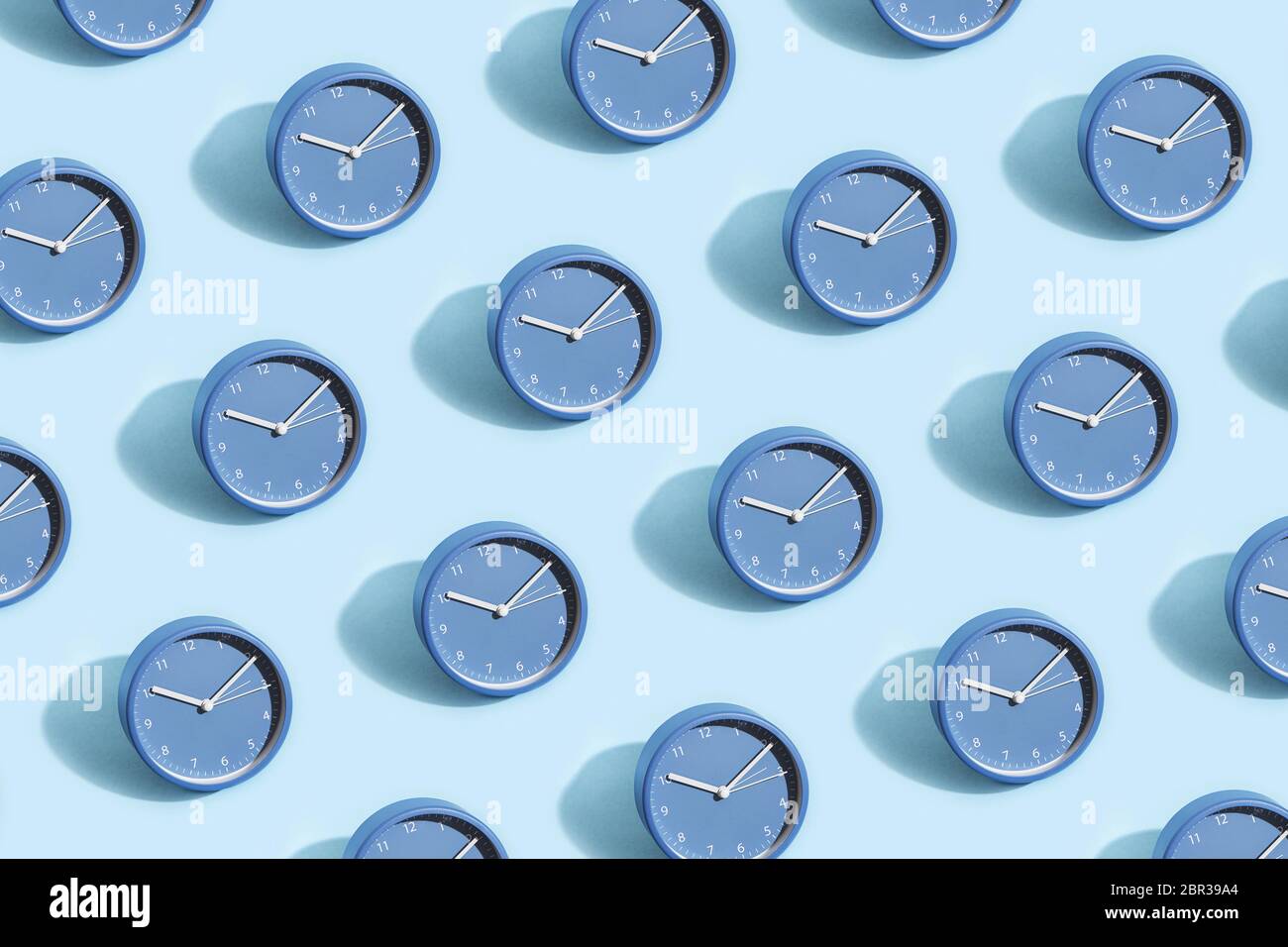 Trendiges Muster aus blauen Uhren auf pastellblauem Hintergrund. Stockfoto