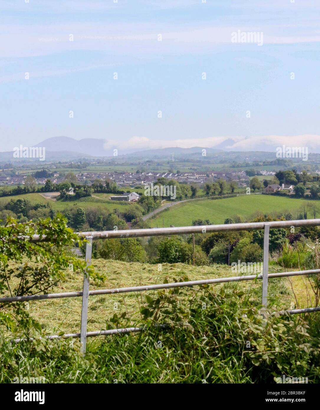 Dromore, County Down, Nordirland. 20 Mai 2020. UK Wetter - ein warmer Tag mit Sonnennyperioden und einer leichten Brise, bevor starker Wind und etwas Regen am Wochenende eintreffen. Jenseits der Stadt Dromore, die Berge von Mourne, an der Küste, sind in niedrigen Wolken gehüllt. Kredit: CAZIMB/Alamy Live News. Stockfoto