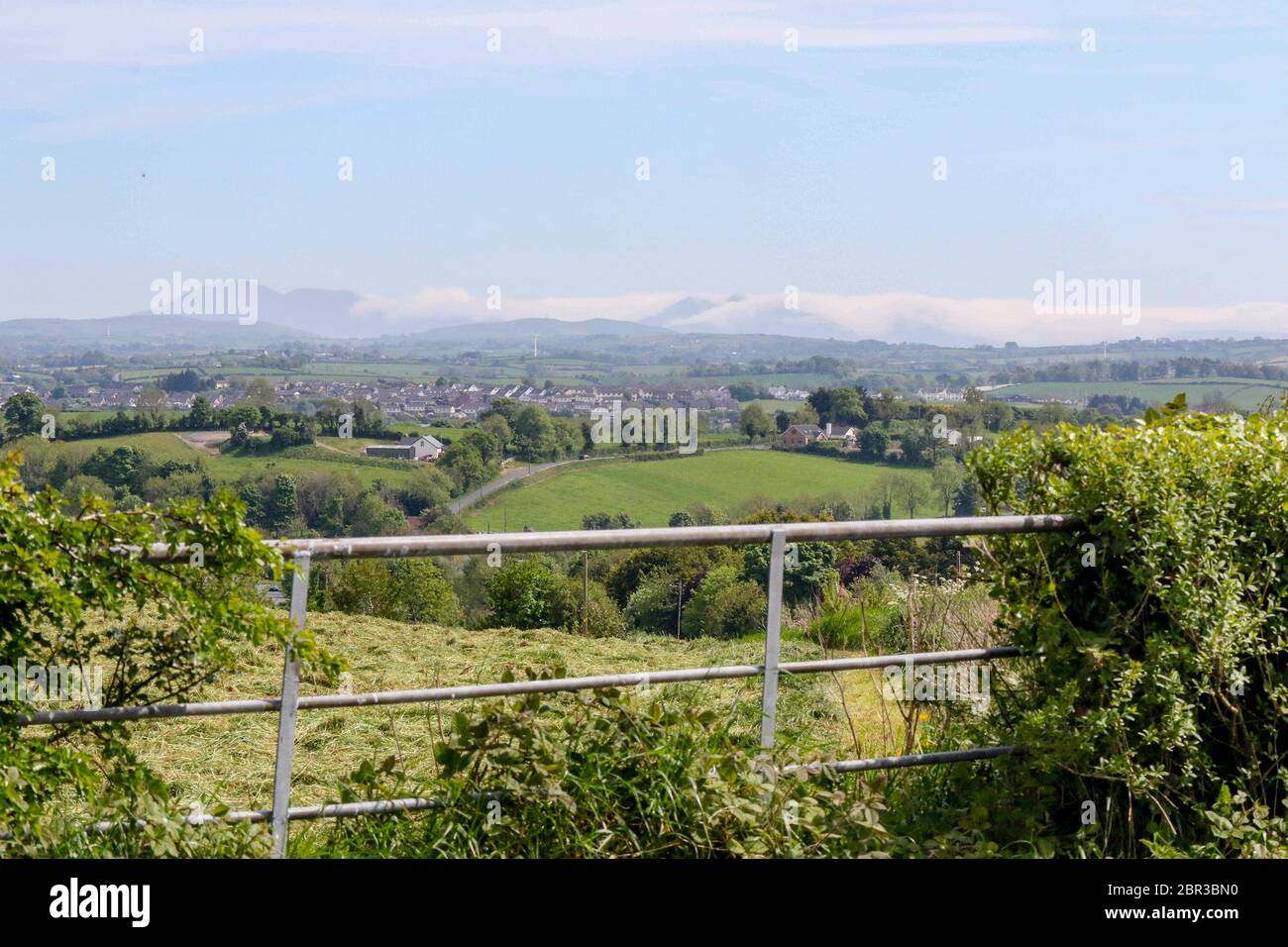 Dromore, County Down, Nordirland. 20 Mai 2020. UK Wetter - ein warmer Tag mit Sonnennyperioden und einer leichten Brise, bevor starker Wind und etwas Regen am Wochenende eintreffen. Jenseits der Stadt Dromore, die Berge von Mourne, an der Küste, sind in niedrigen Wolken gehüllt. Kredit: CAZIMB/Alamy Live News. Stockfoto