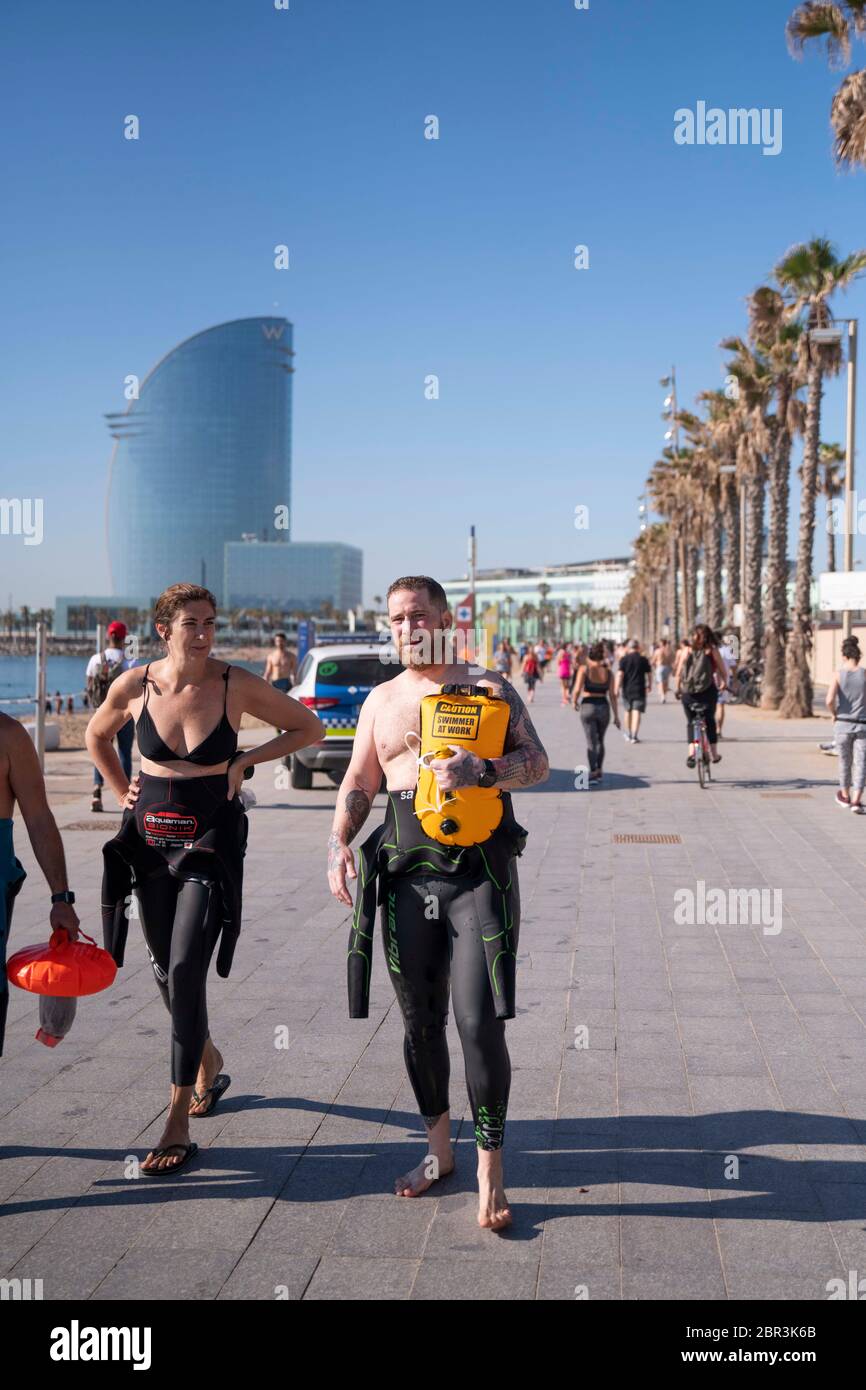 Ein Paar mit dem Neoprenanzug, der am 20. Mai 2020 nach dem Paddelsurfen am Strand Barceloneta in Barcelona, Spanien, aufgesetzt wurde. Die Stadt bleibt weiterhin auf der Stufe Null der allmählichen Dekompression der Beschränkungen der Einsperrungen. Trotzdem werden Sicherheitsmaßnahmen Tag für Tag aktualisiert. Ab heute von 18 bis 22 Uhr ist es neben der Praxis der individuellen Sportarten, die vor Wochen erlaubt sind, unter Beachtung der Sicherheitsdistanz auf dem Sand zu laufen. Sonnenbaden ist verboten. Spanien steht wegen der Coronavirus-Pandemie vor dem 66. Tag des Ausnahmezustands. Die Zahl der Krankenhauseinweisungen sinkt, aber Todesfälle s Stockfoto
