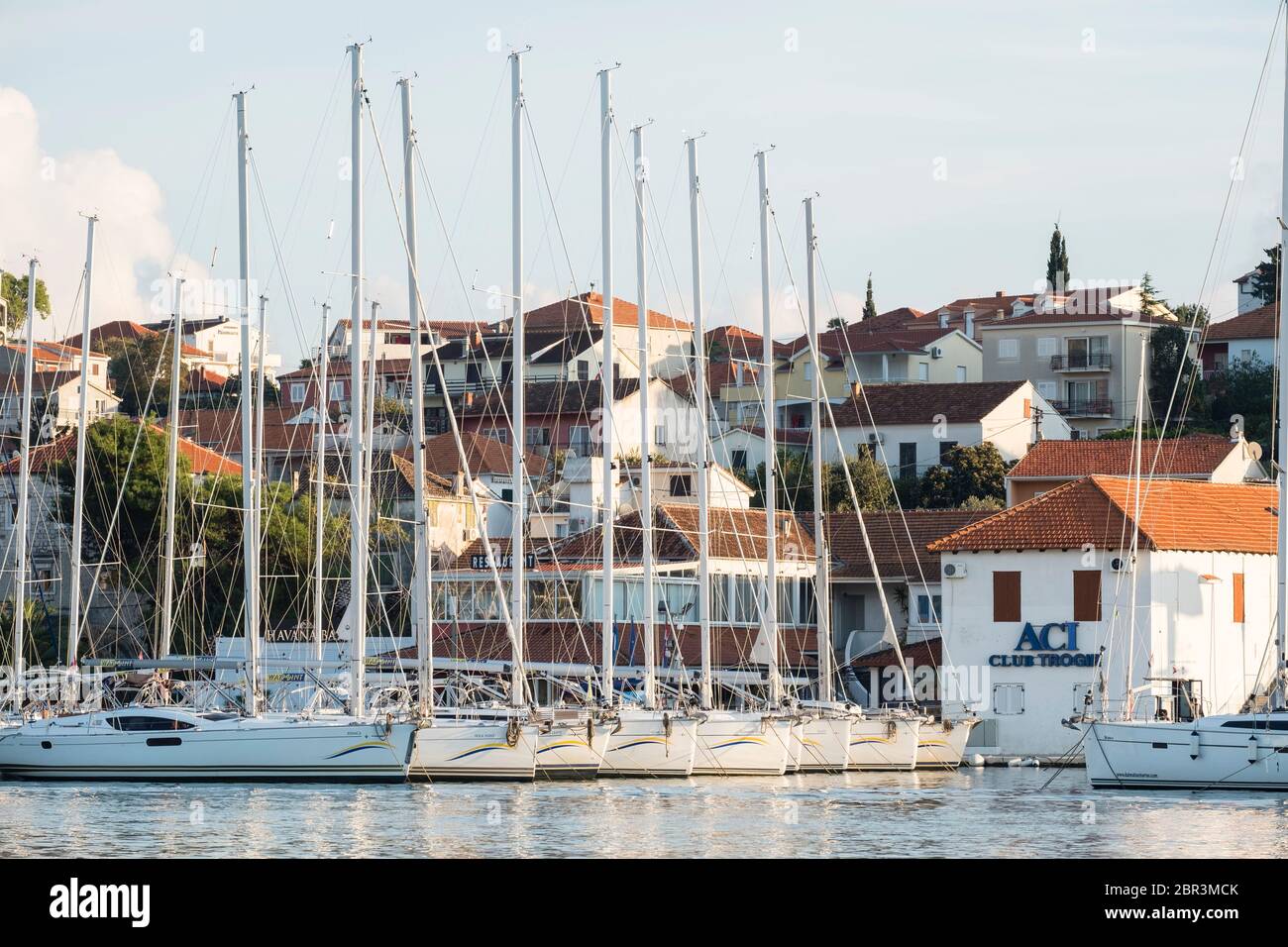 Blick auf die Marina Trogir und die Insel Ciovo, mit mehreren Segelbooten vor ACI Club Trogir angedockt, und mittelalterlichen Residenzen in der Nähe. Stockfoto
