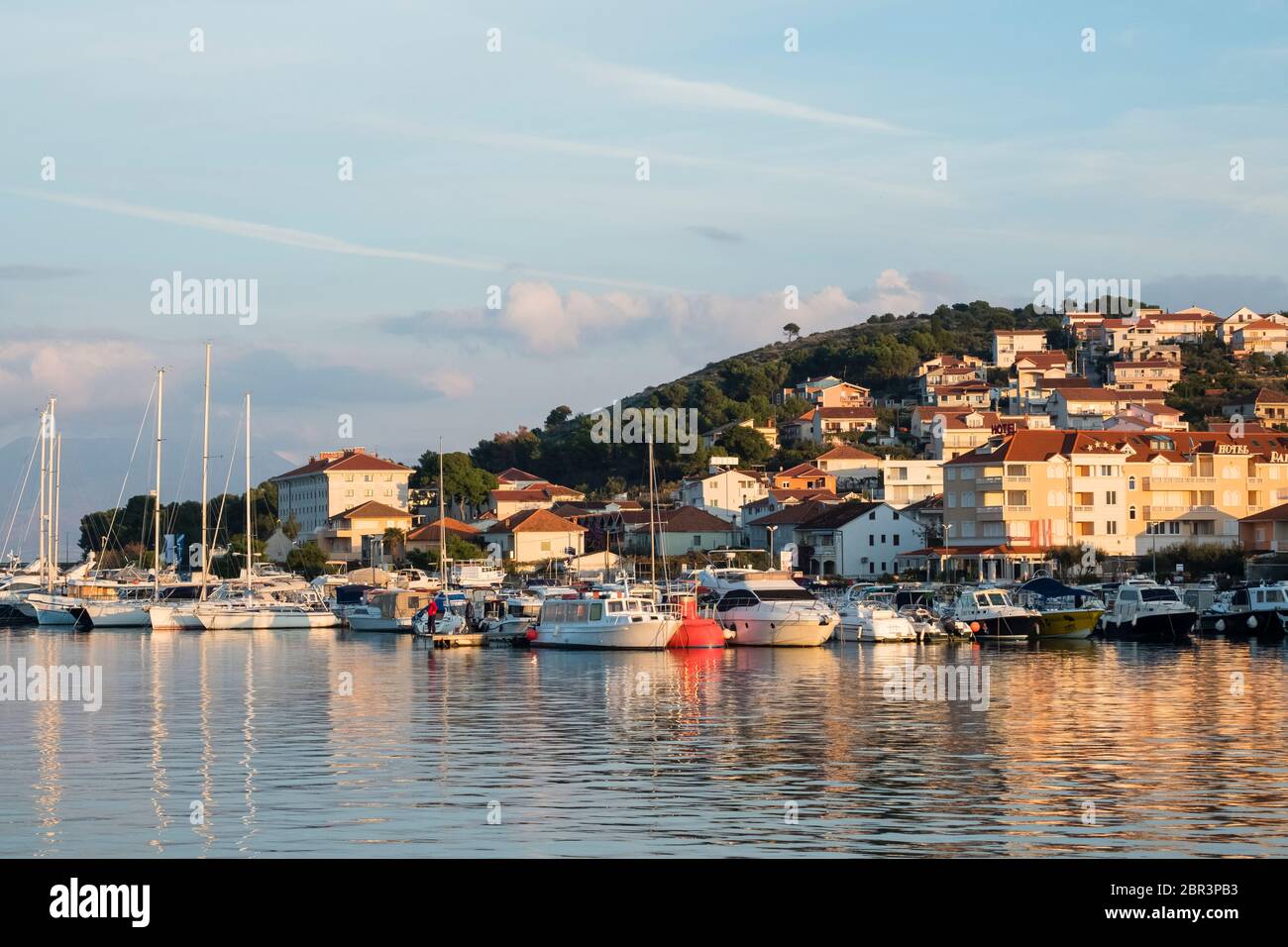 Blick auf die Marina Trogir und die Insel Ciovo, mit mehreren Booten angedockt und mittelalterlichen Residenzen in der Nähe. Stockfoto