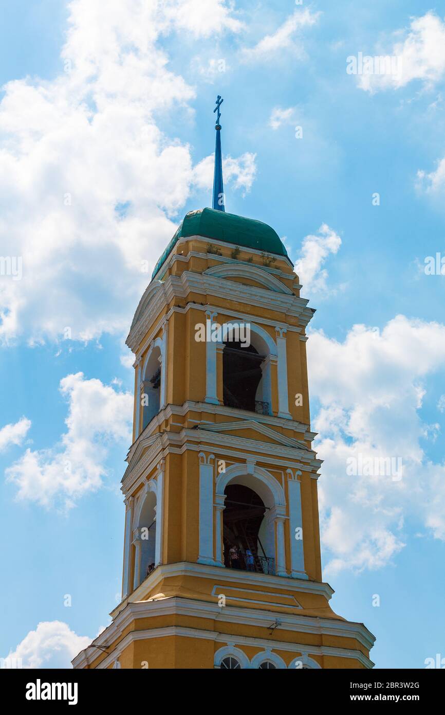 Gelbe orthodoxe christliche Kirche mit einem grünen Kuppel vor einem blauen Himmel mit weißen Wolken. Stockfoto