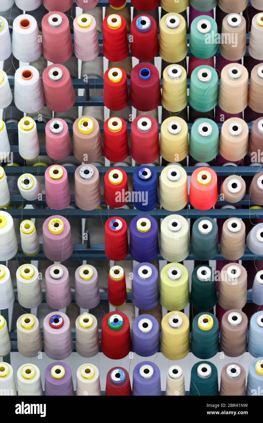 Sortiment an farbigen Fadenspulen in einer italienischen Haute Couture Firma Stockfoto