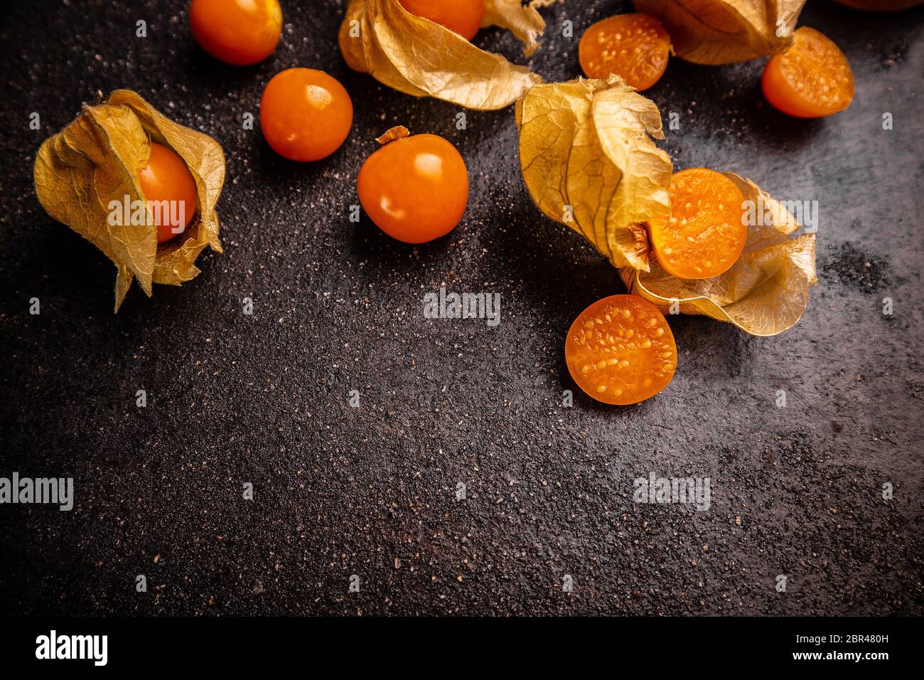 Frische Kap Stachelbeeren, sehr lecker und gesund Beerenfrucht auf schwarzem Hintergrund Stockfoto