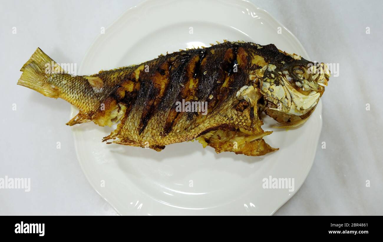 Ein ganzer fusilier Fisch, gebraten und auf einem Teller serviert. Draufsicht. Stockfoto