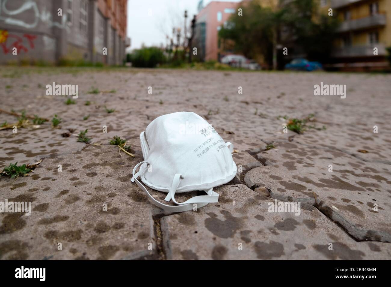 Astrrakhan / Russland - 20. Mai 2020: Gebrauchte, medizinische Maske auf einem Bürgersteig. Wahrscheinlich verloren oder weggeworfen. Einwegmaske, zur Verhinderung der Virusausbreitung. Stockfoto