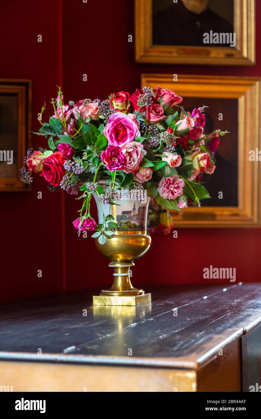 Vase mit einem schönen frischen Blumenstrauß im Inneren eines alten Palastes. Die Zustellung der Blumen in einer Vase aus Porzellan im Vintage Style. Renaissa Stockfoto