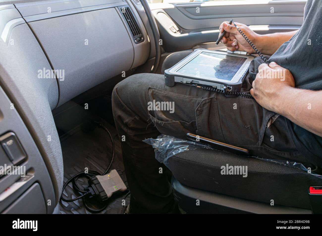 Mechaniker prüft mit dem Computer die möglichen Fehler, die das Fahrzeug registriert hat Stockfoto