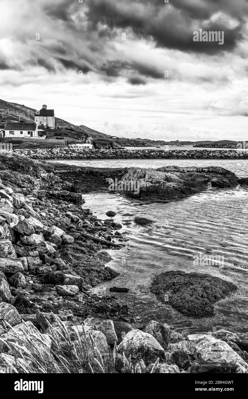 Regenwolken über Häusern an der felsigen und steinigen Küste Schottlands Stockfoto
