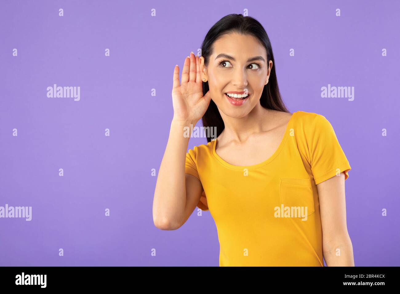 Neugierig schöne Mädchen Hand in der Nähe des Ohres Stockfoto