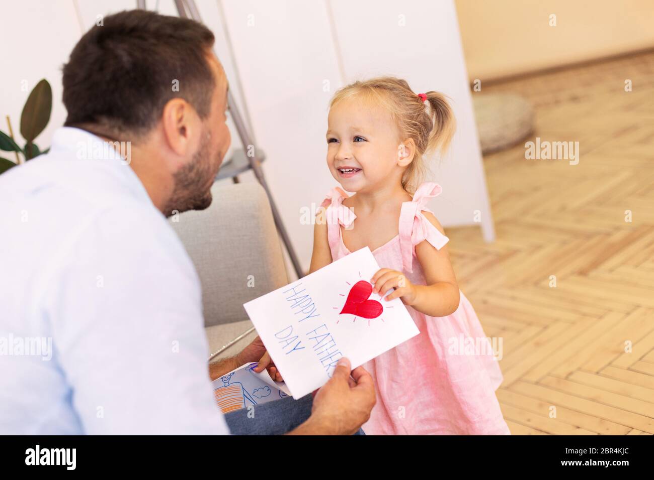 Kleine Tochter gratuliert Vater mit Vatertag Stockfoto