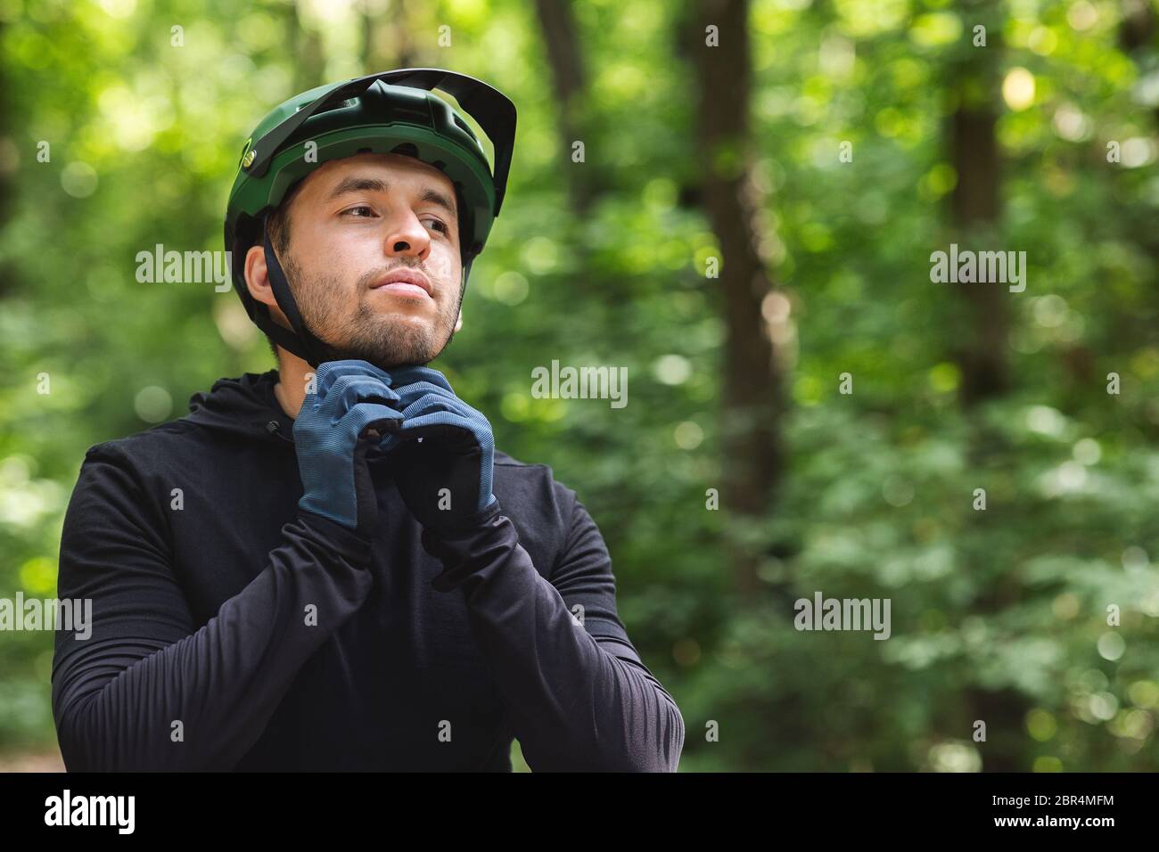 Radfahrer Mann trägt seinen Sporthelm auf Wald Hintergrund Stockfoto