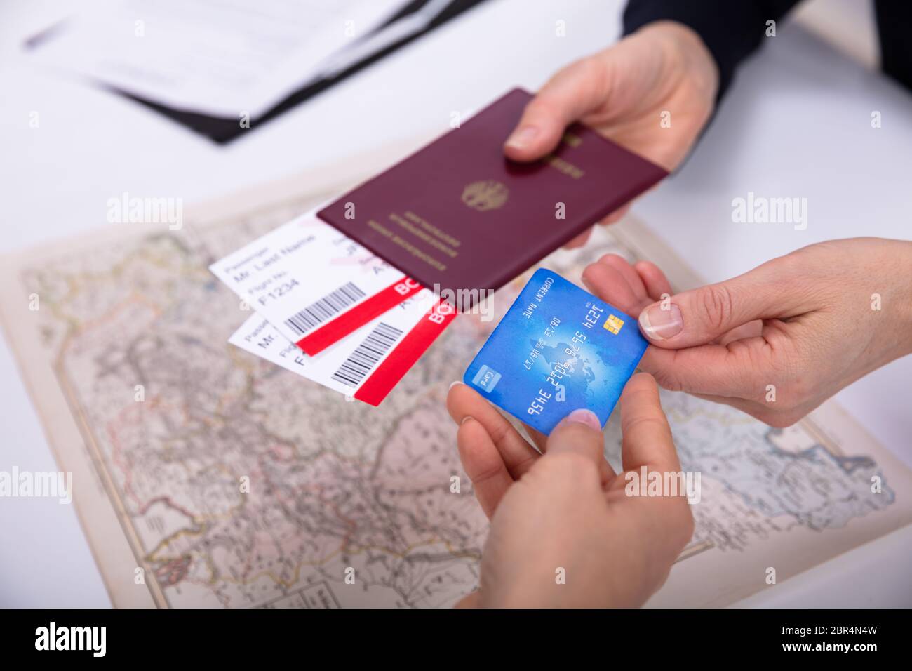 Der Menschen Hand mit Reisepass und Bordkarte Ticket mit ATM-Karte über Welt Karte Stockfoto