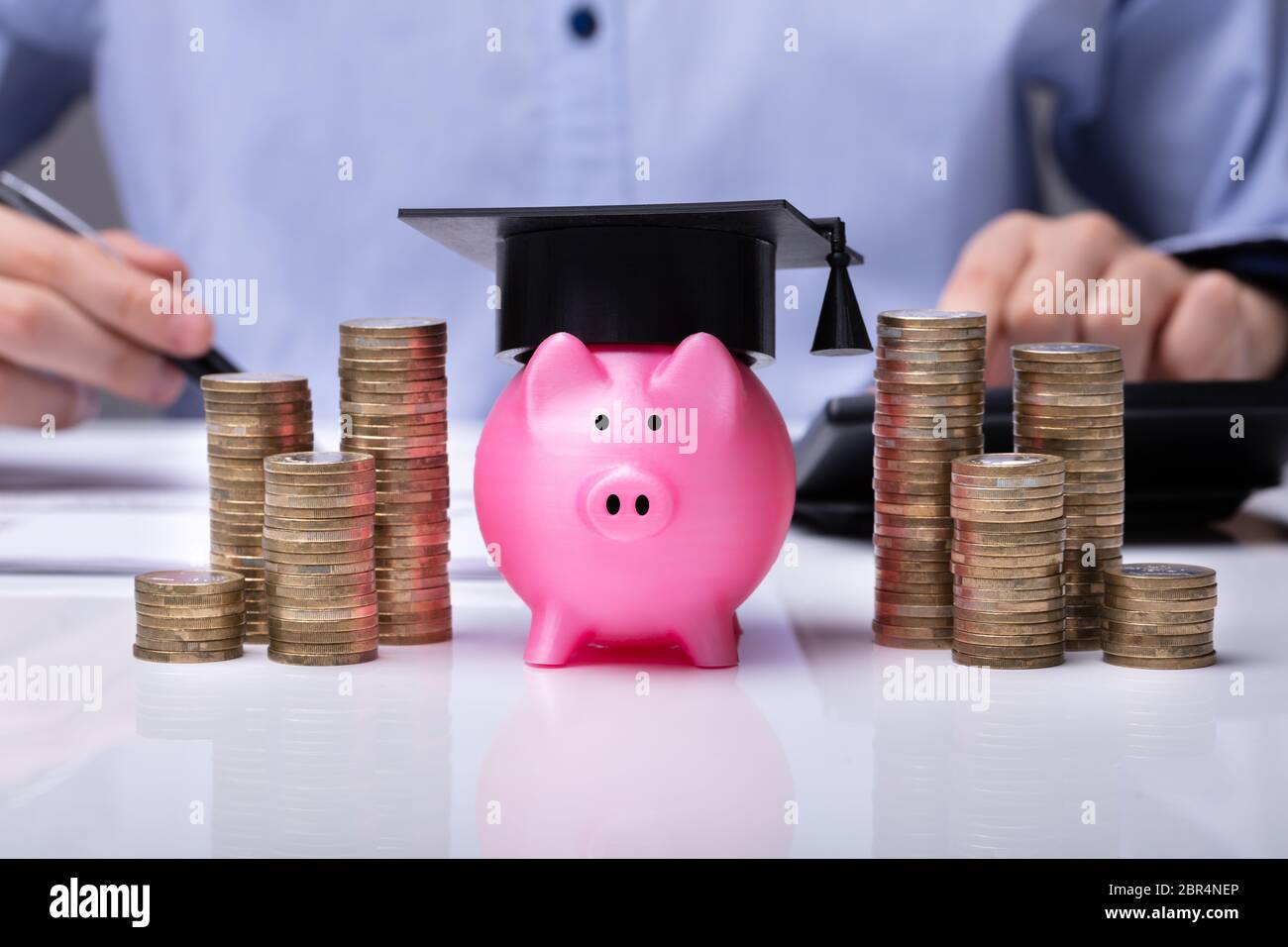 In der Nähe von Piggy Bank tragen Staffelung hat und gestapelte Münzen Vor Unternehmer Stockfoto