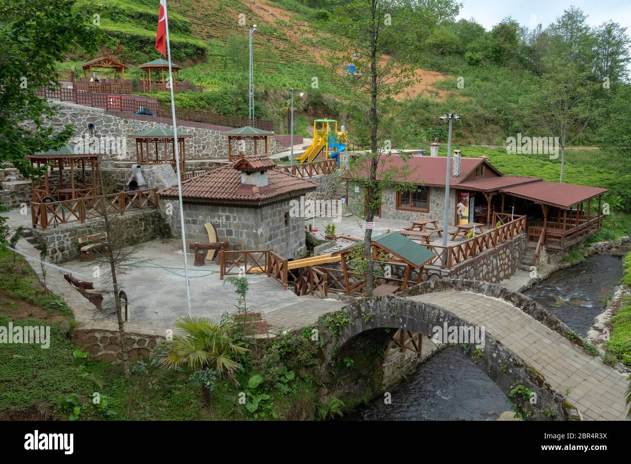 Ein Park mit einer historischen Bogenbrücke und einer Wassermühle in der Stadt iyidere in Rize. Stockfoto