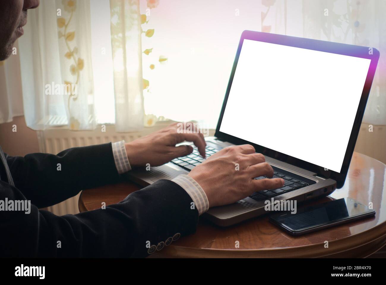 Mann, der mit dem Laptop auf einem Tisch zu Hause tippt und surft, leerer Platz für Bildschirmkopien Stockfoto