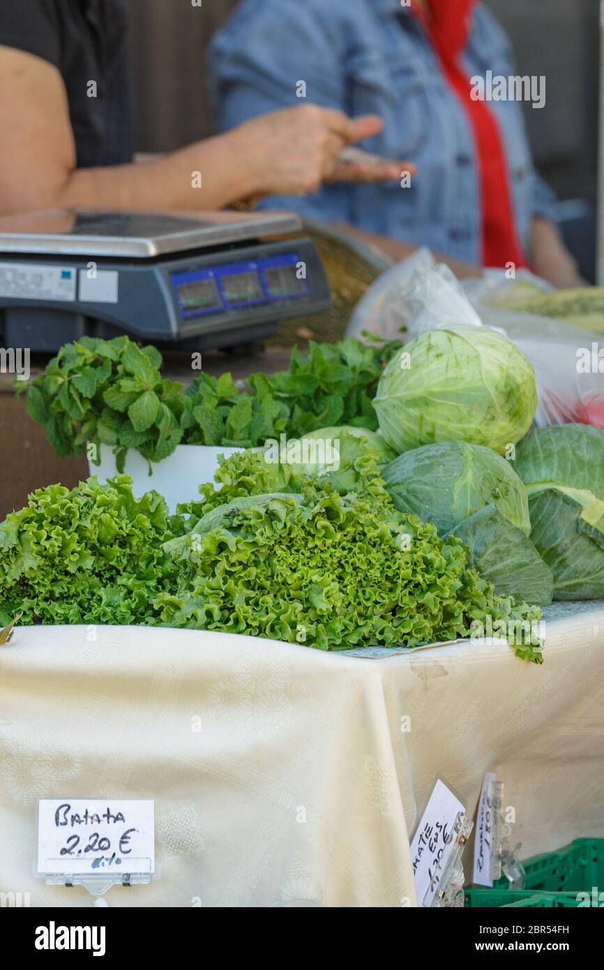 Festlicher Agrarmarkt. Eine der Theken mit frischem Gemüse ist Zucchini, Kohl, Salat, Koriander und vieles mehr. Der Besitzer des Theke s Stockfoto