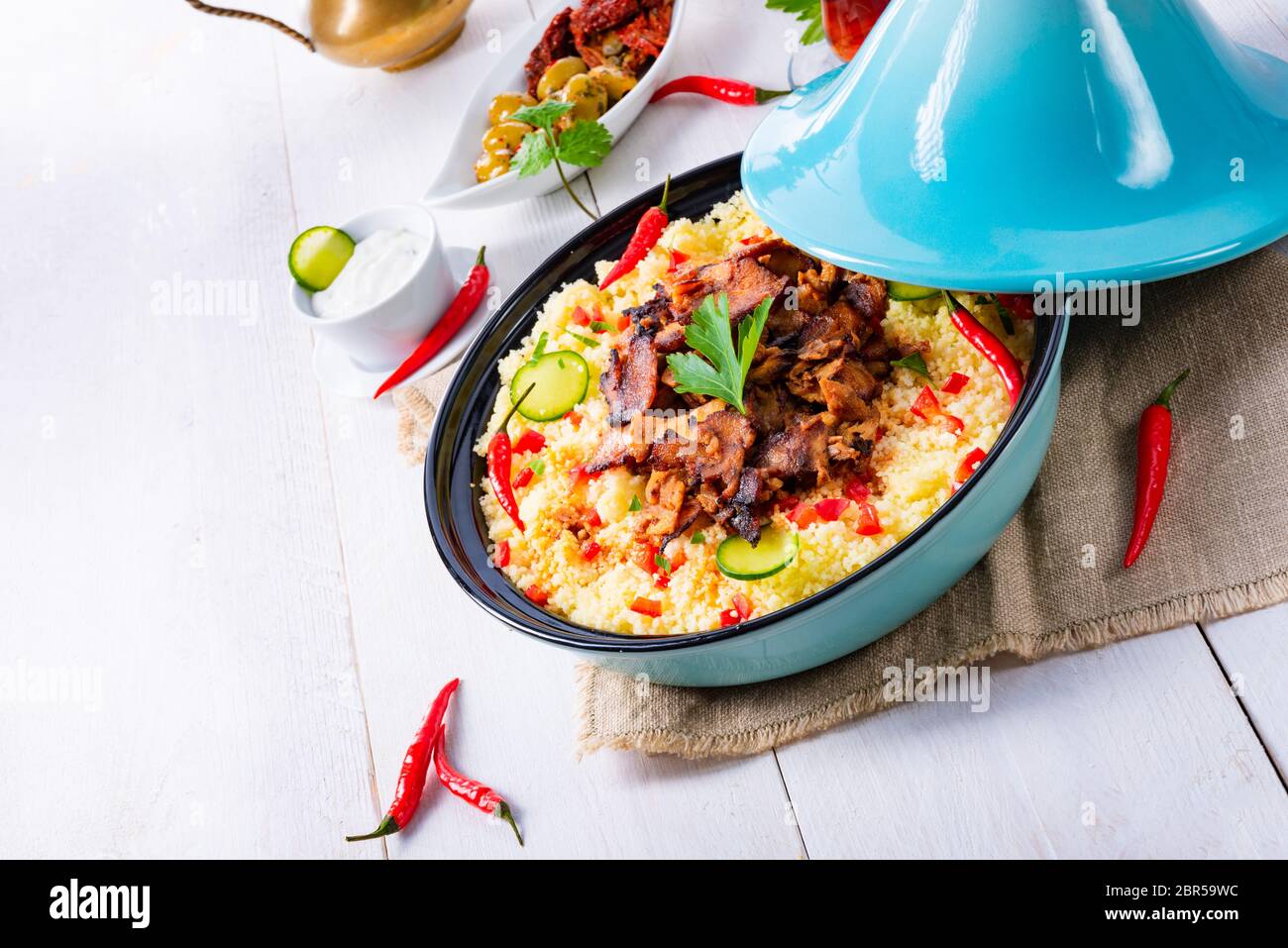 Tajin mit Couscous, Gemüse und Fleisch auf weißem Hintergrund Stockfoto