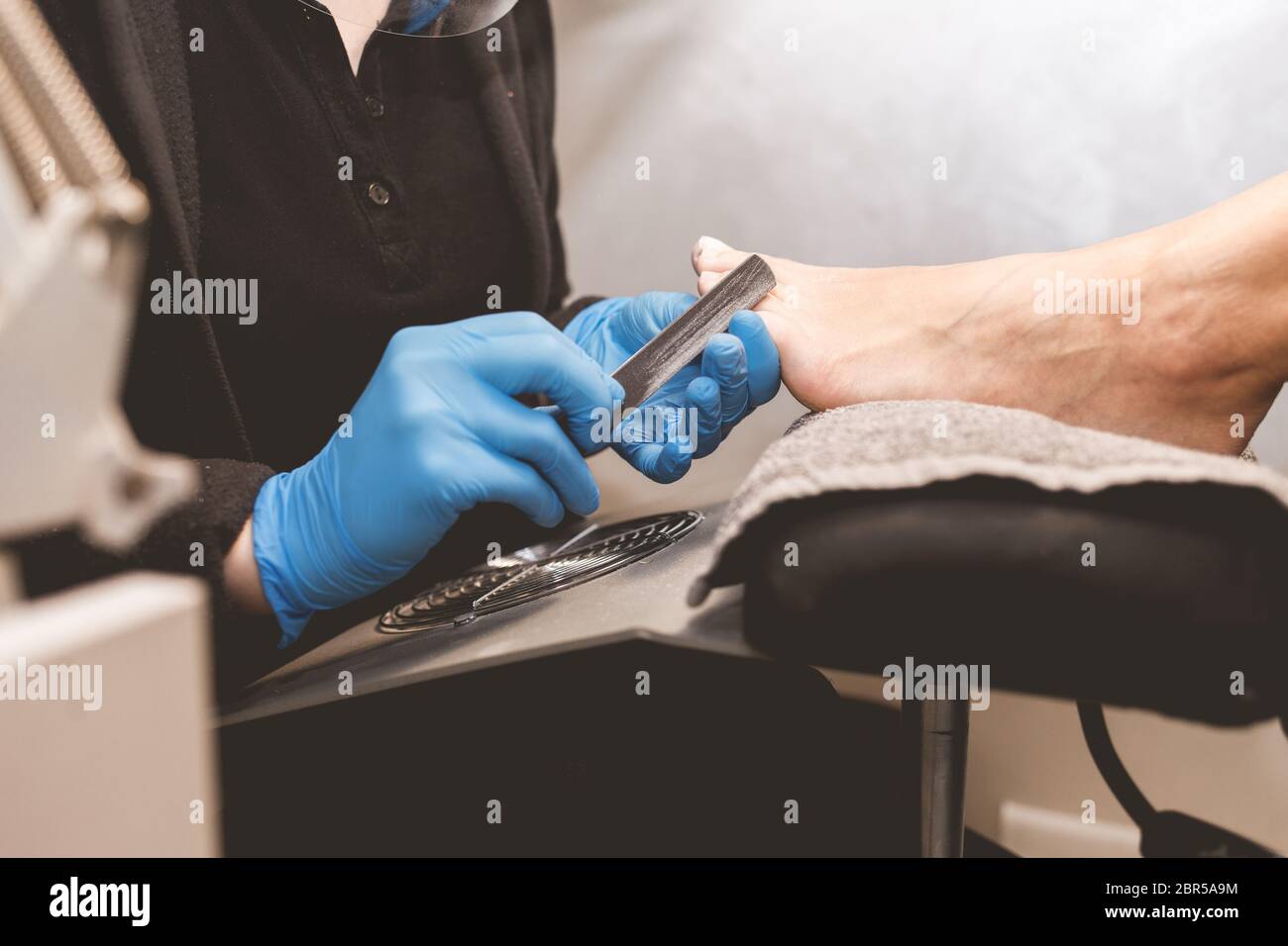 Pediküre Master-Dateien Nägel mit einer Nagelfeile für die nachfolgende Anwendung des Lackes Stockfoto