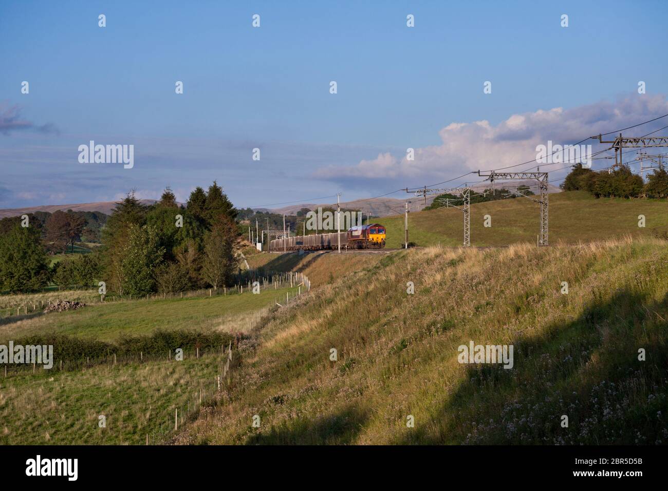 DB Cargo Class 66 Lokomotive in EWS livery vorbei Lambrigg (nördlich von Oxenhome auf der West Coast Mainline) mit einem Güterzug Kalk Durchführung Stockfoto