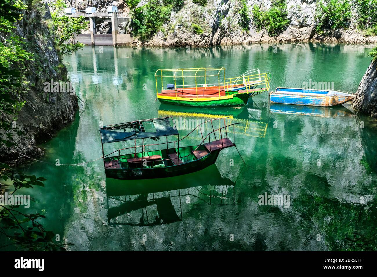 Alte schroffe und bunte Boote dockten in der kleinen Bucht am Matka Canyon, Skopje, Mazedonien Stockfoto