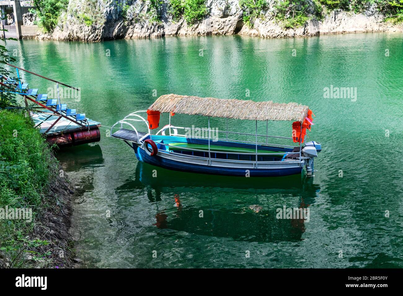 Transport von kleinen Touristen Blaues Boot dockte in der kleinen Bucht am Matka Canyon, Skopje, Mazedonien Stockfoto